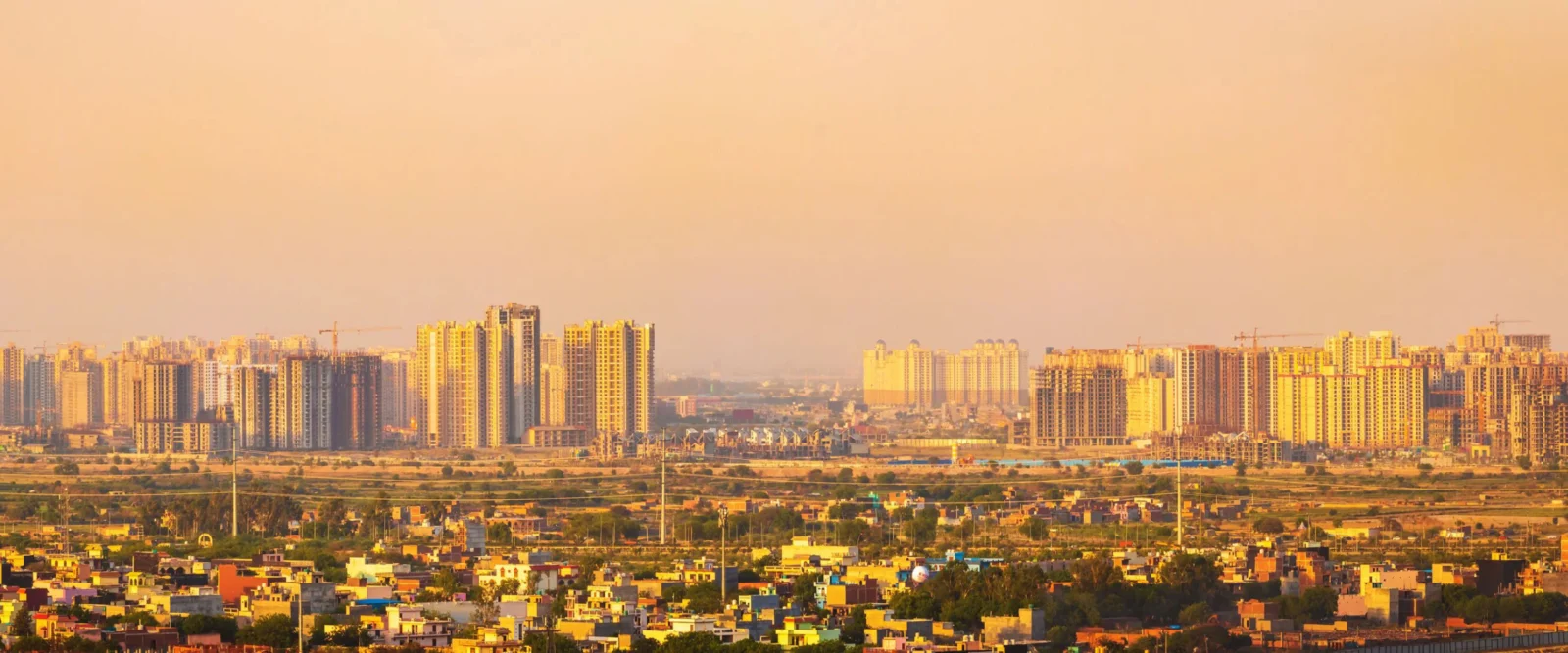 Greater Noida West skyline at sunset, with high-rise residential towers under construction